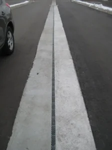 Slotted drain pipe installed in roadway median for continuous runoff collection