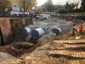 Construction of underground stormwater infrastructure beneath a campus expansion project.
