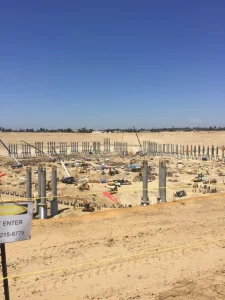 Corrugated steel pipe isolation casing installed around a stadium support column.