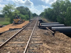 Polymer-coated structural plate assembled to create a buried bridge structure.