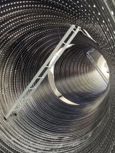 Interior view of a large-diameter underground retention system featuring maintenance access ladders and inspection points.