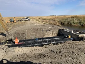 Polymer-coated steel outlet pipe installed to restore water control infrastructure at the wildlife refuge.