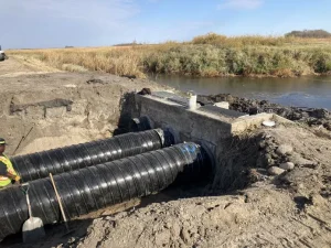 Polymer-coated steel outlet pipe installed to restore water control infrastructure at the wildlife refuge.