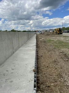 Concrete drainage channel constructed to improve track drainage and driver safety.