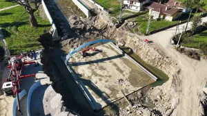 Aerial view of corrugated steel bridge assembly beginning on the prepared foundation in Düzce.