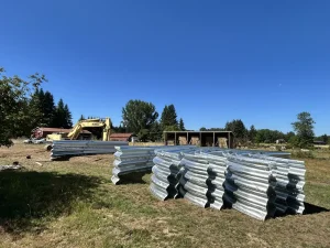 Corrugated structural steel plate sections staged for assembly at the Messing Creek bridge replacement site.