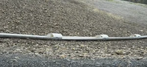 ITD downdrain 3_resized Long section of partially open corrugated steel downdrain installed across steep highway terrain in Idaho.