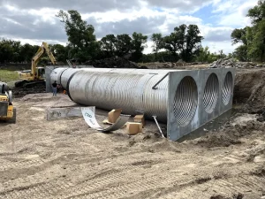 Burke SD Triple 120in CHS (2)_resized Three large-diameter corrugated steel culvert barrels with metal headwalls positioned at the Gregory County construction site.