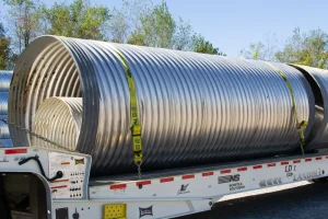 Large corrugated steel pipe sections nested for delivery on a trailer