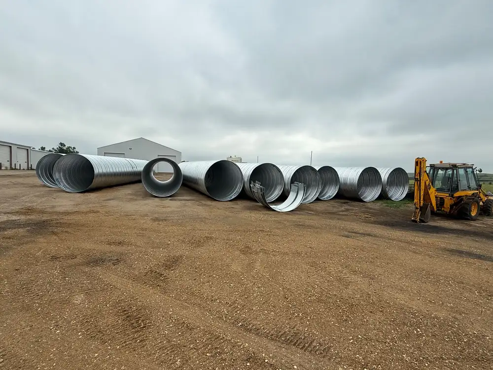 Large-diameter galvanized corrugated steel pipe sections staged for the Oliver County culvert replacement.